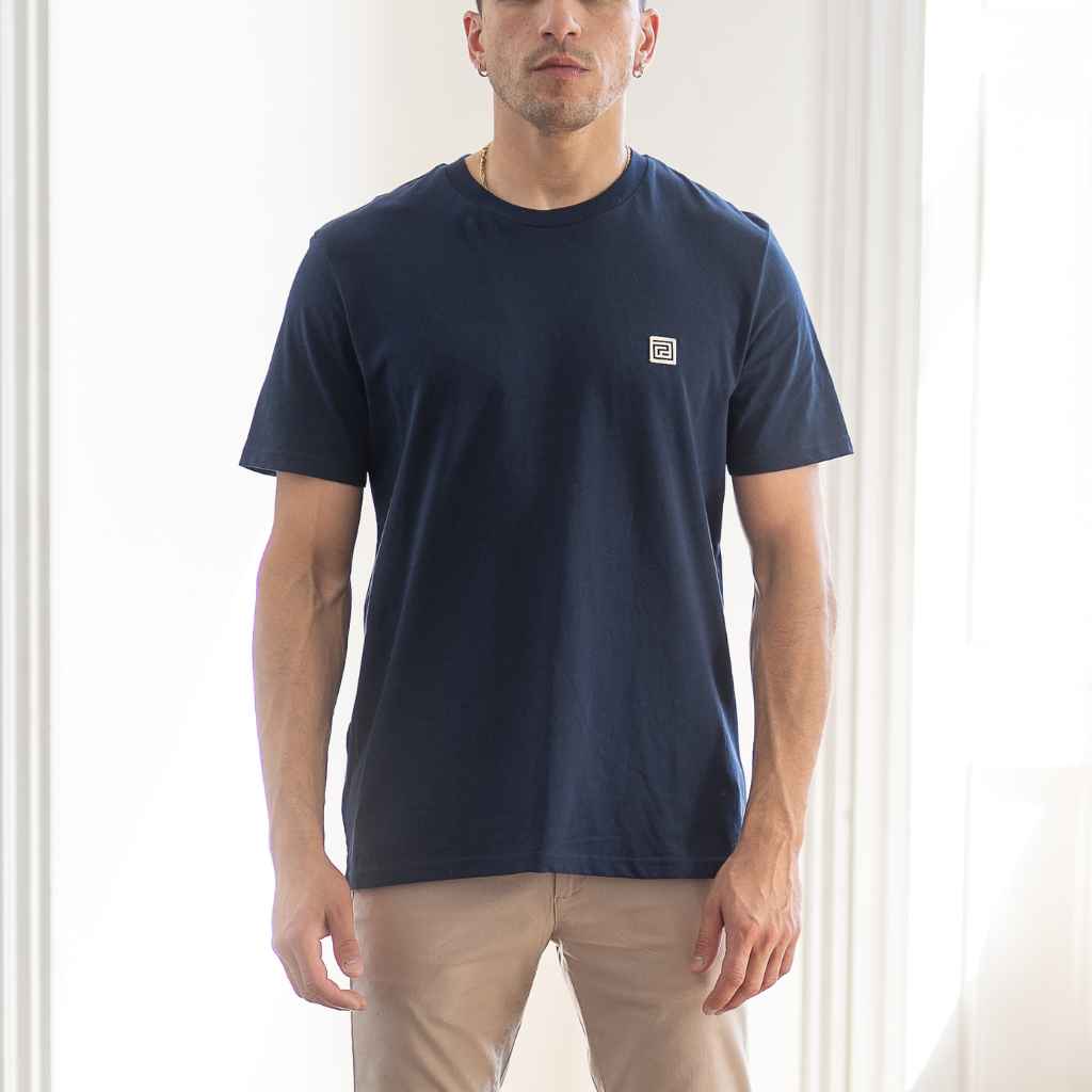 A man wearing a navy blue classic paradaiza crewneck T-shirt with a small white logo on the chest.