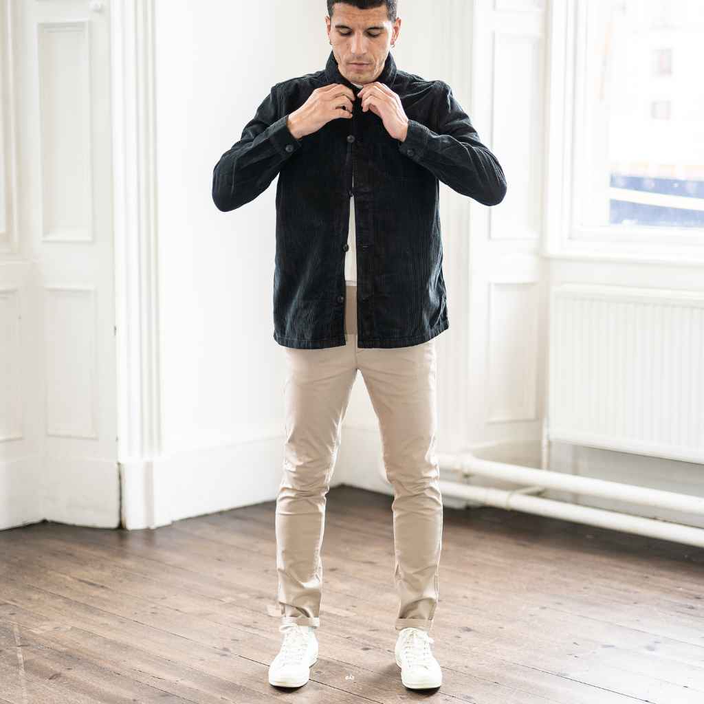 A male model wearing a para daiza long-sleeved black overshirt with a collar, patch chest pocket, and buttons down the front.