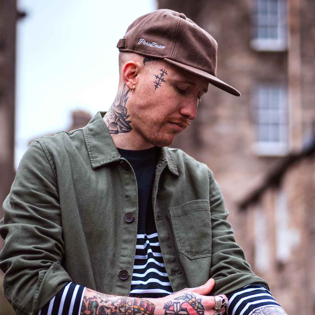 model wears paradaiza classic wool cap with stripe tee and worker jacket