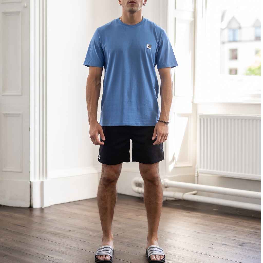 A male model wearing a blue classic crewneck pardaiza t-shirt with a small branded logo on the chest.