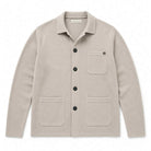 Paradaiza beige knitted worker jacket  with a collar, black buttons, a chest pocket, and two lower patch pockets, shown flat on a white background.