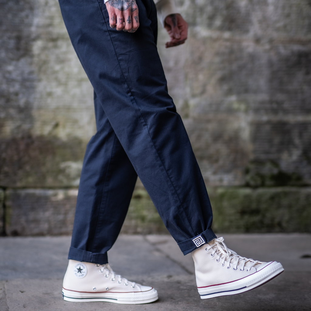 model wears navy pinch chinos and converse