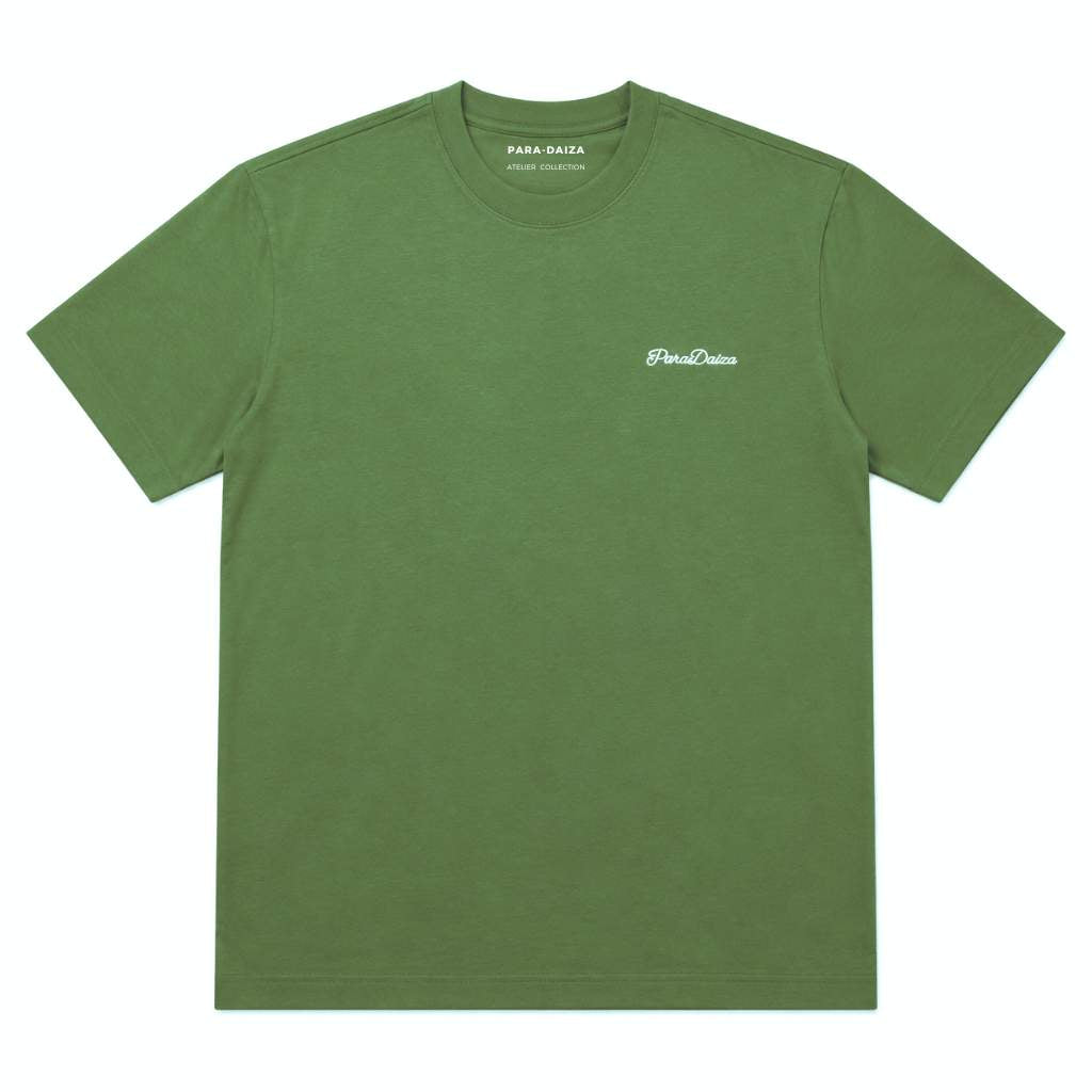 An green crewneck t-shirt by PARA-DAISA, featuring a small white embroidered logo on the left chest, displayed flat against a solid white background.