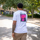 Person wearing a paradaiza white t-shirt with a colorful graphic on the back, standing in stockbridge edinburgh 