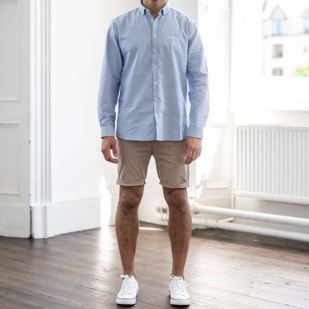 paradaiza model wears blue shirt beige shorts and white canvas shoes