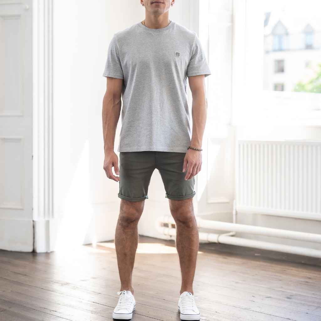 paradaiza model wears khaki shorts, grey t-shirt and white canvas shoes