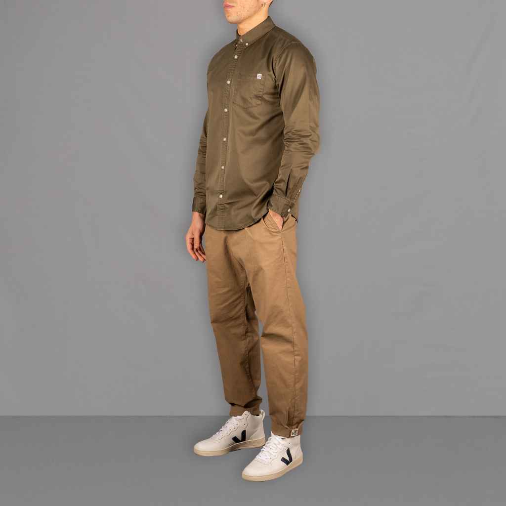 Model wears Para-Daiza button down khaki shirt with our pinch chino  and Veja sneakers 