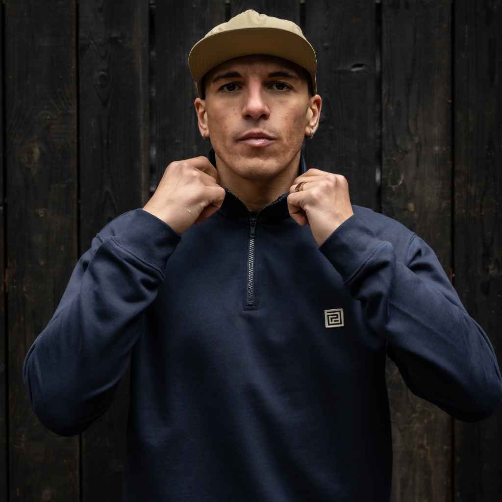 model wears paradaiza 1/4 zip navy sweat and cap