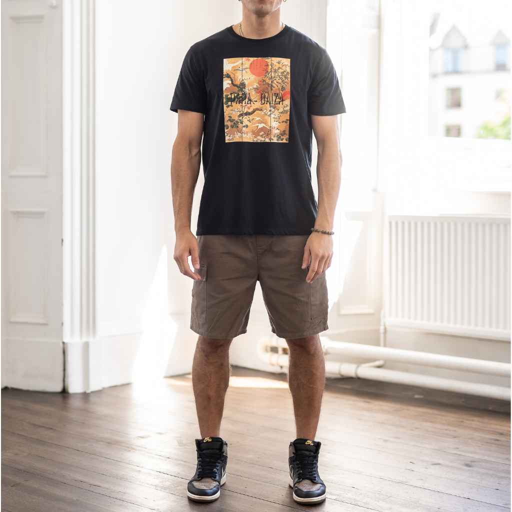 model wears paradaiza cargo shorts and graphic tee 