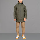 model wears a khaki waterproof parka and chinos