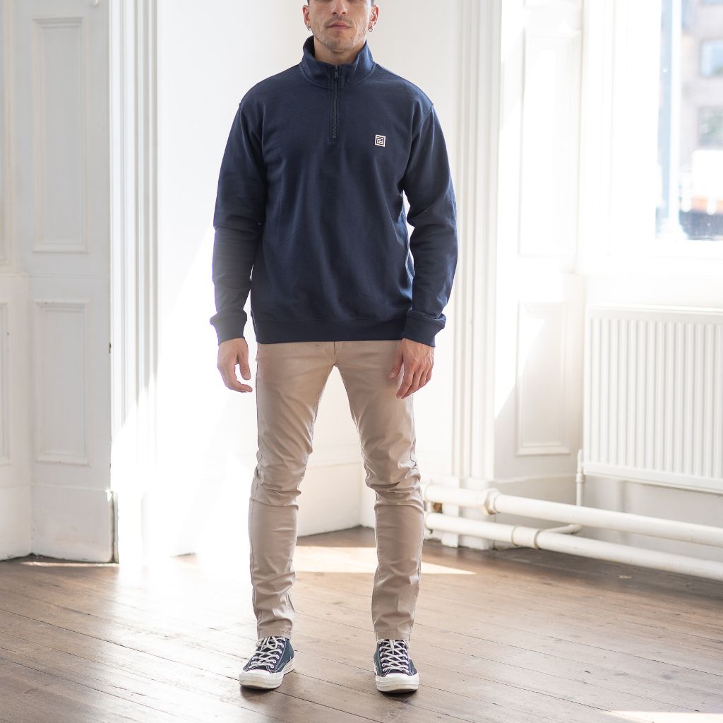 model wears paradaiza 1/4 zip navy sweat and slim sand chino