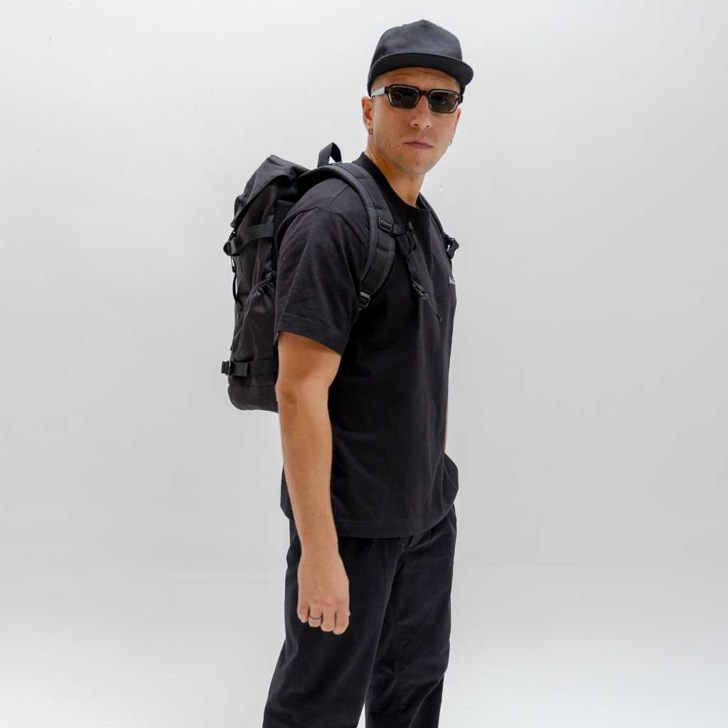 Person wearing a black PARADAIZA backpack with a visible brand logo on a plain background