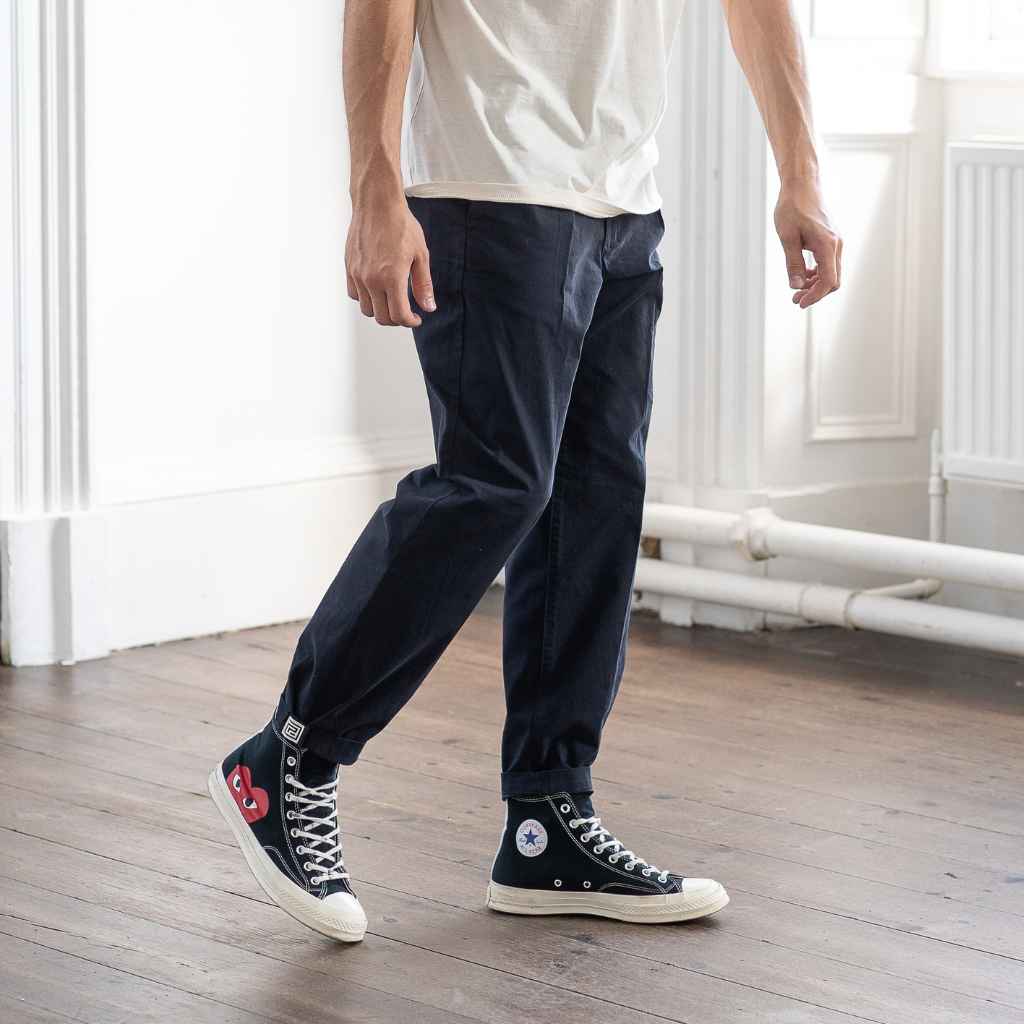 model wears paradaiza pinch tapered chinos  with com des garcon coverse