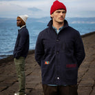 Model wearing a  paradaiza dark blue worker jacket with patterned accents and sashiko stitching  