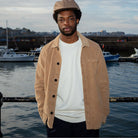 A person wearing a Paradaiza tan corduroy overshirt with a collar, buttons, and a patch chest pocket.