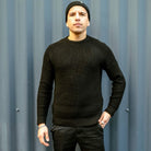 Man wearing a paradaiza black knit against a gray background