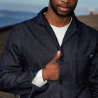 Man wearing a paradaiza dark denim jacket against a gray background