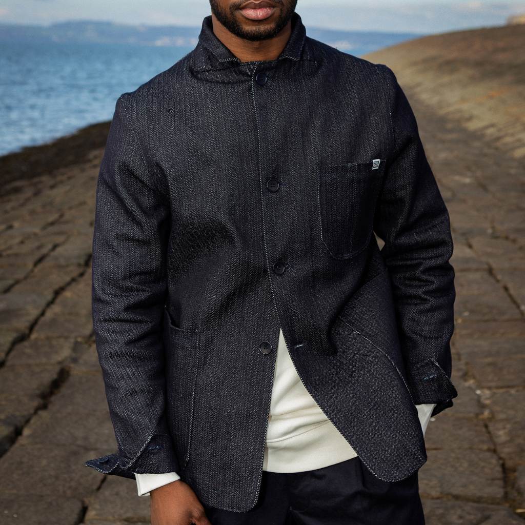 Man wearing a paradaiza dark denim jacket against a gray background