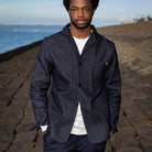 Man wearing a paradaiza dark denim jacket against a gray background