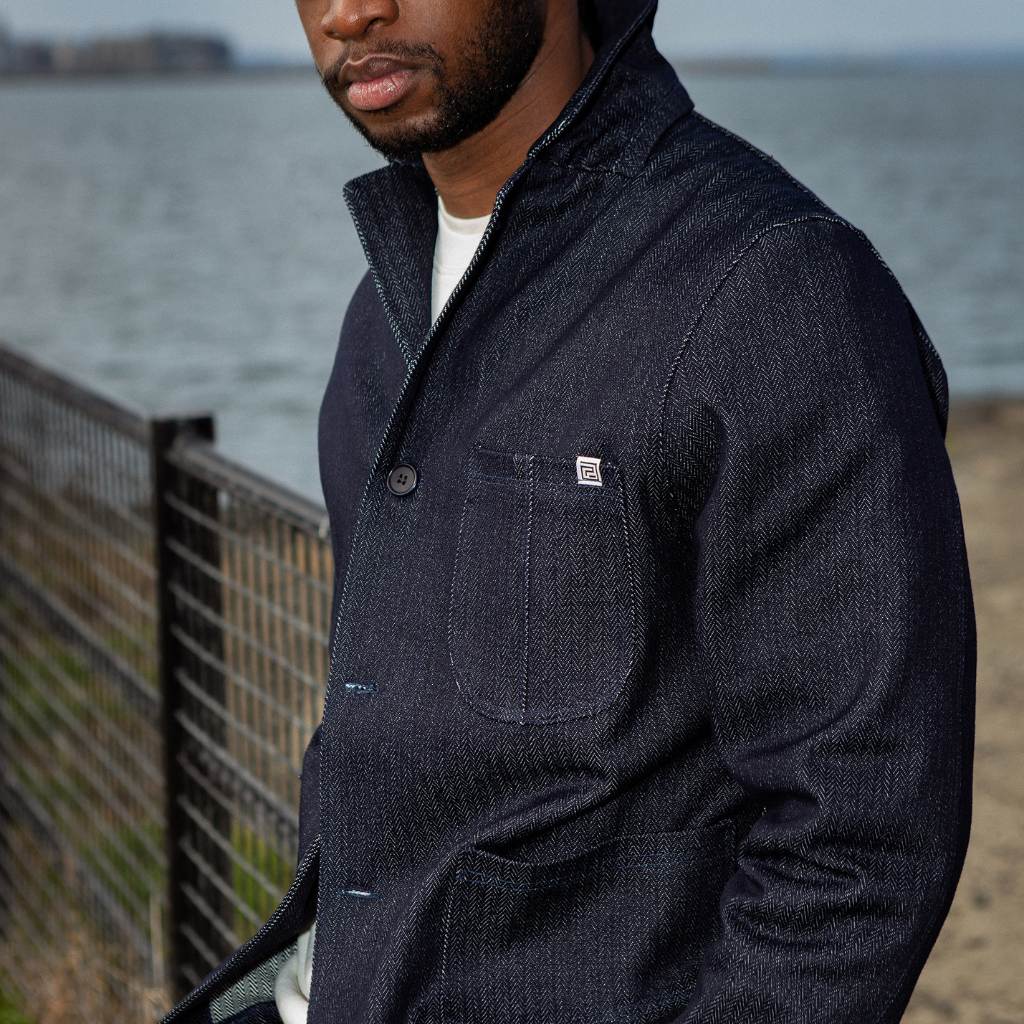 Man wearing a paradaiza dark denim jacket against a gray background
