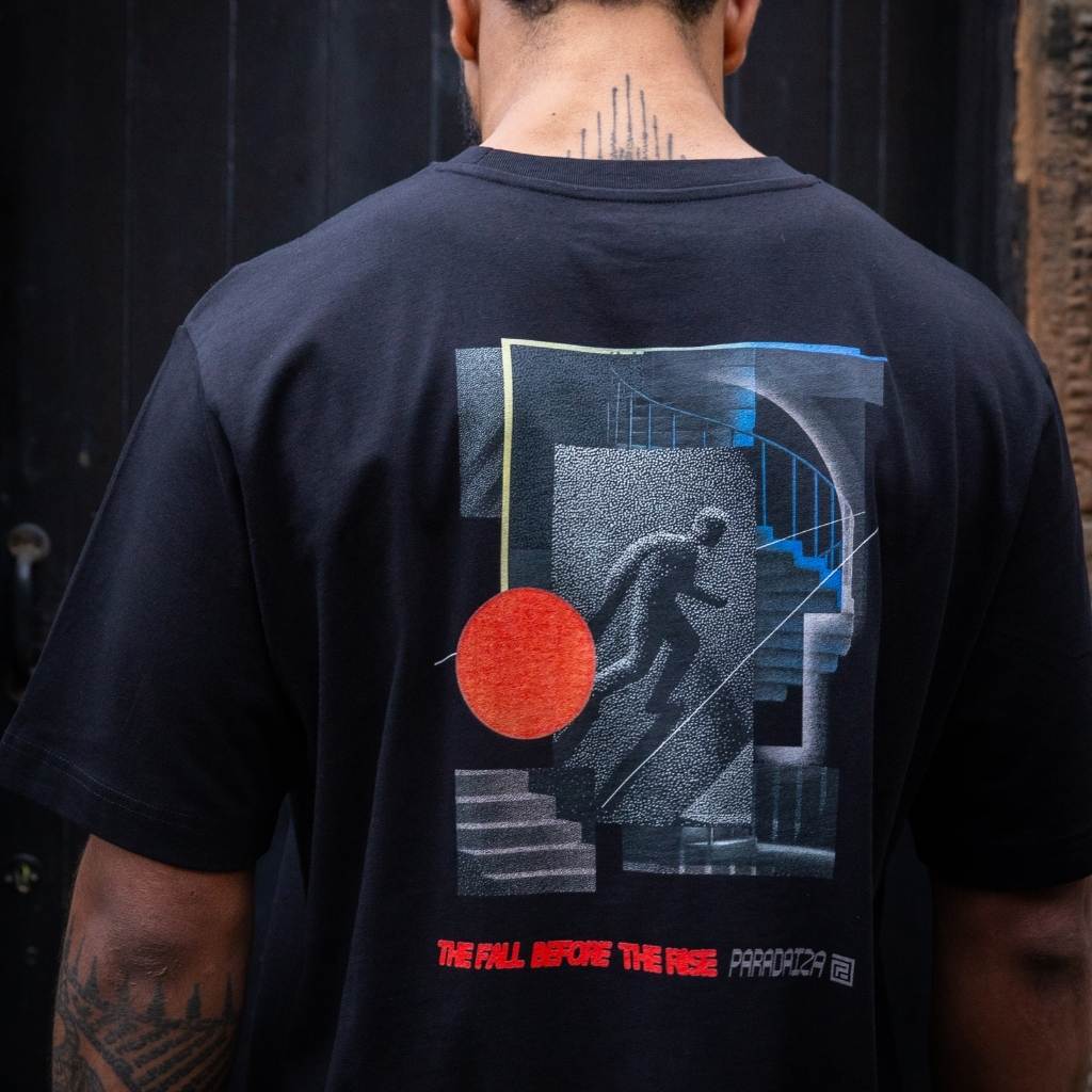 man wearing Paradaiza Black t-shirt with a graphic design on the back against wall in stockbridge 