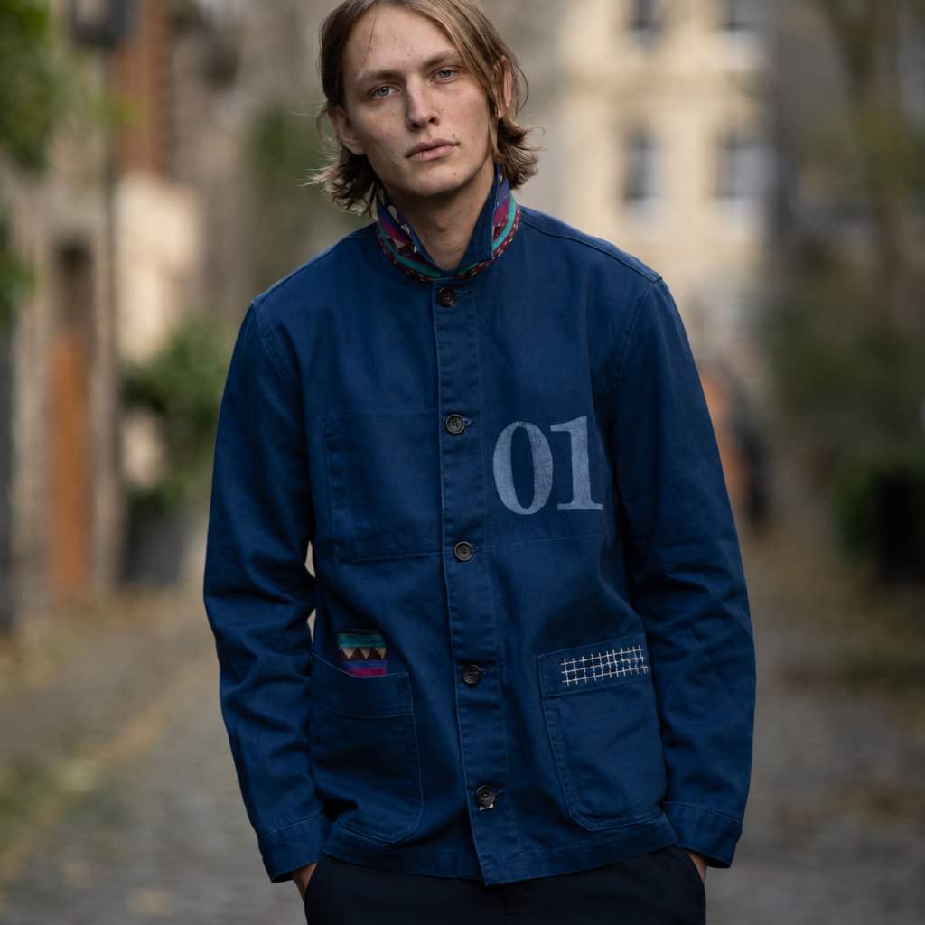 Person wearing a blue PARA-DAIZA atelier jacket with '01' on it, standing outdoors in Stockbridge.