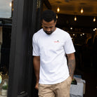 Man wearing a paradaiza white t-shirt with a logo, standing out side the paradaiza store in stockbridge edinburgh 
