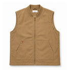 A tan zip-up vest with a stand collar, two front patch pockets, and a small red brand tab on the left pocket, shown flat against a white background.