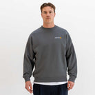 Man wearing a grey paradaiza sweatshirt with a logo on a white background