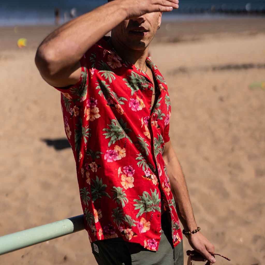 Model wears red Paradise Print Shirt in red at the beach