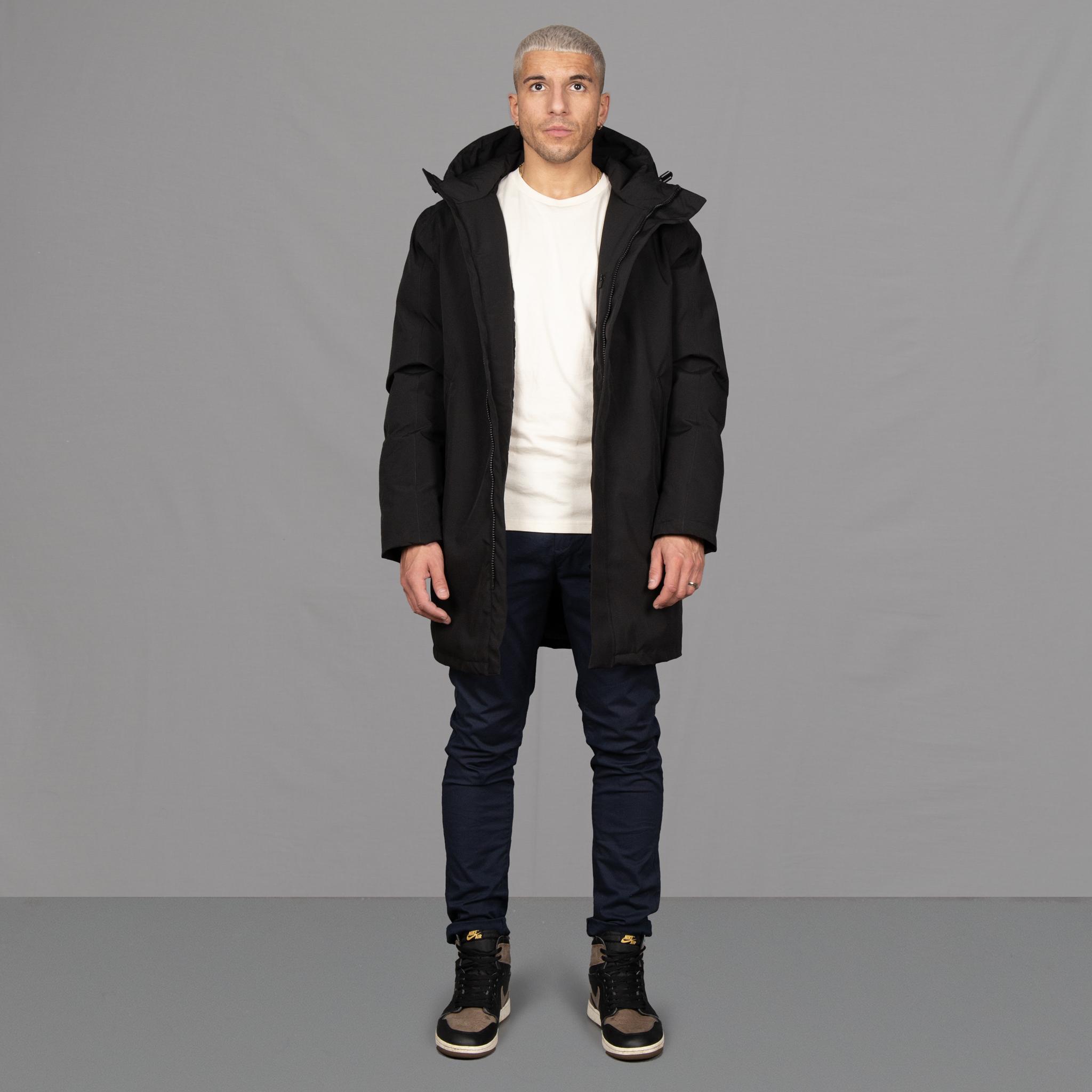 Model wears Para-Daiza Black padded parka superflex chino, off-white tee, and Nike trainers. 