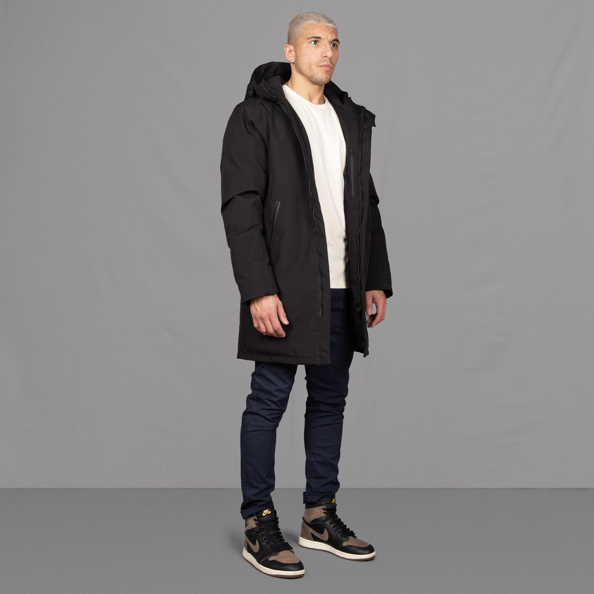 Model wears Para-Daiza Black padded parka superflex chino, off-white tee, and Nike trainers. 