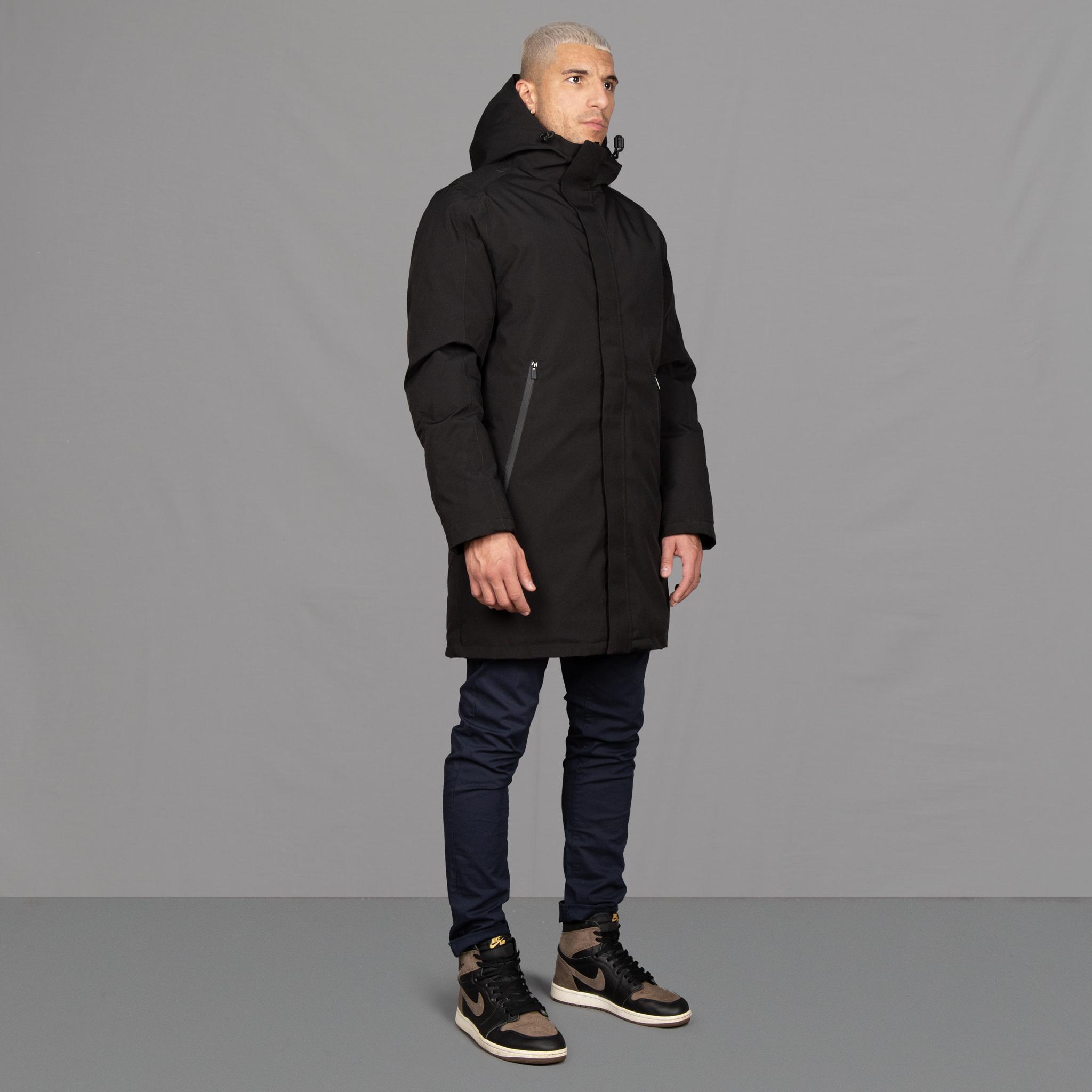 Model wears Para-Daiza Black padded parka superflex chino, off-white tee, and Nike trainers. 