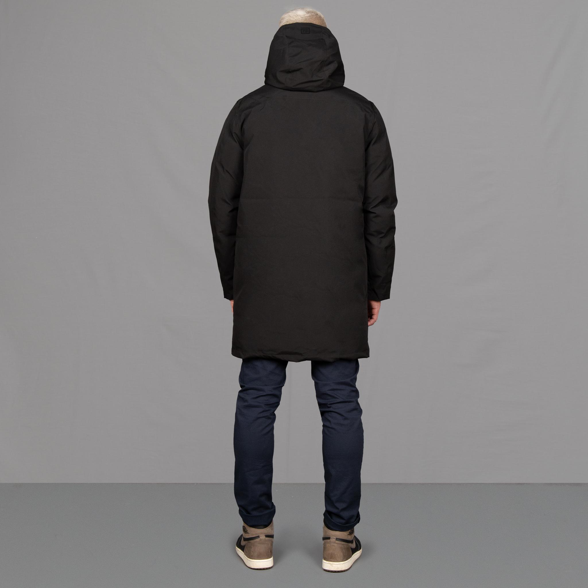 Model wears Para-Daiza Black padded parka superflex chino, off-white tee, and Nike trainers. 