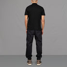 The model wears Para-Daiza Black Core Polo Shirt, pinch chino and Nike trainers.