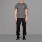 The model wears Para-Daiza Grey Core Polo Shirt, pinch chino and Nike trainers.