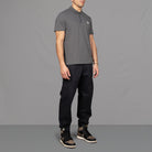 The model wears Para-Daiza Grey Core Polo Shirt, pinch chino and Nike trainers.