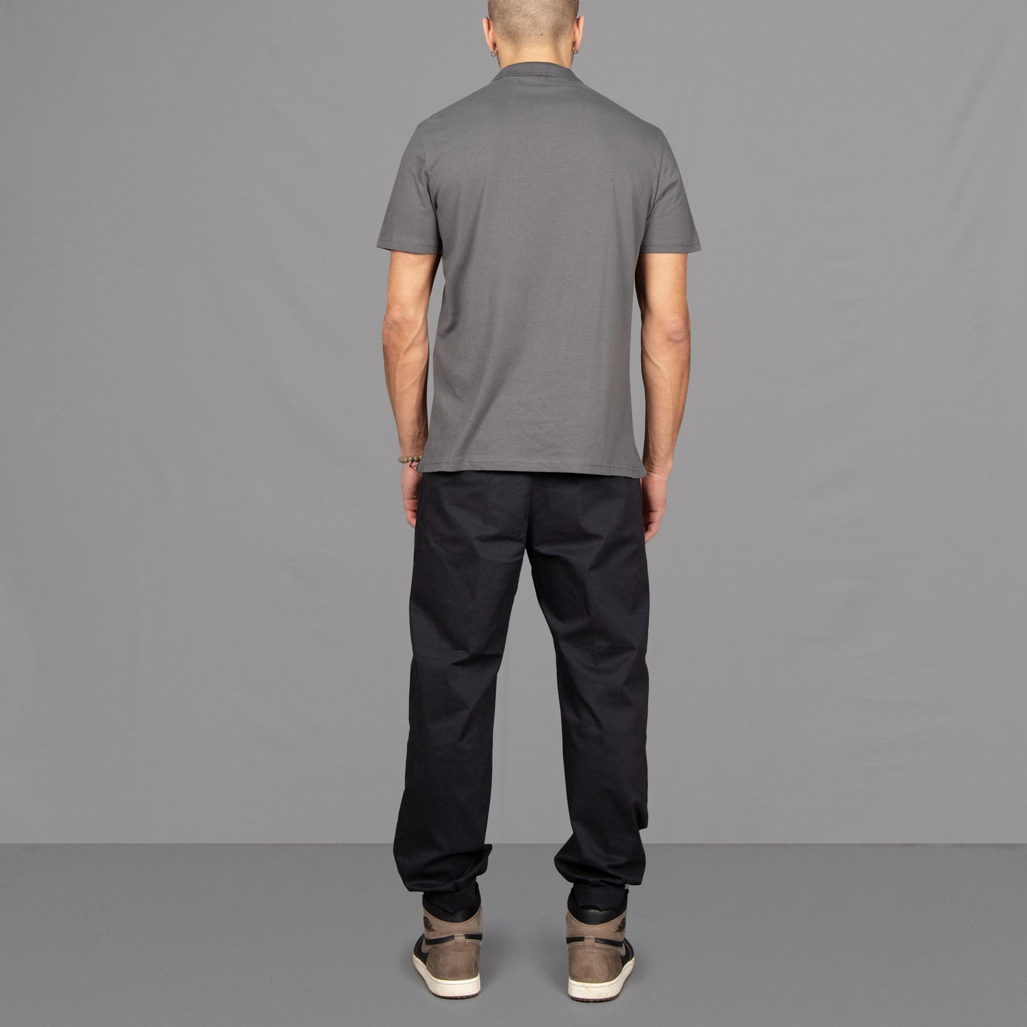 The model wears Para-Daiza Grey Core Polo Shirt, pinch chino and Nike trainers.