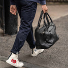 Man holding a  paradaiza black leather weekend bag
