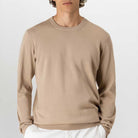 Person wearing a paradaiza beige sweater on a plain background