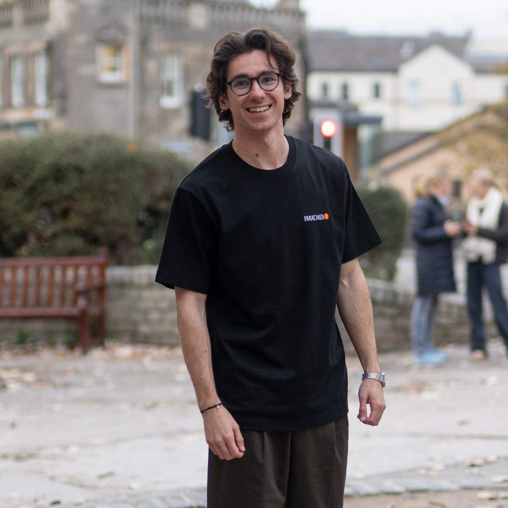 Black t-shirt with 'Chasing the Beyond' graphic design on a textured gray background