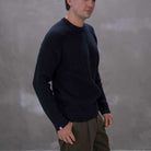 Man wearing a paradaiza black knit against a gray background