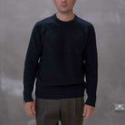 Man wearing a paradaiza black knit against a gray background