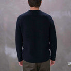 Man wearing a paradaiza black knit against a gray background