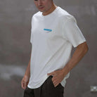 Person wearing a paradaiza white t-shirt with colorful design and text, 