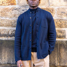 Person wearing a paradaiza jacket standing against a stone wall.