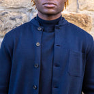 Person wearing a paradaiza jacket standing against a stone wall.