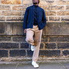 Person wearing a paradaiza jacket standing against a stone wall.