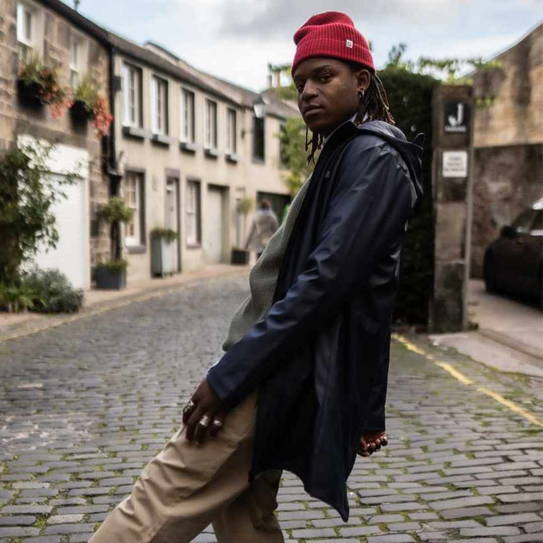 A male model wearing a Paradaiza navy parka jacket with a hood