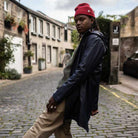 A male model wearing a Paradaiza navy parka jacket with a hood